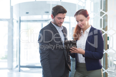 Business executives discussing over digital tablet