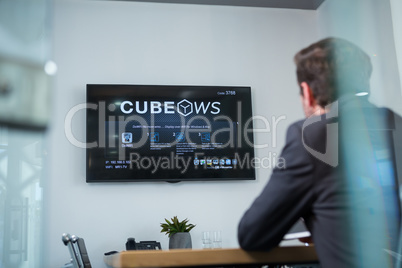 Rear view of businessman watching television