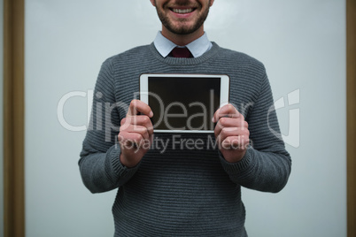 Smiling executive holding digital tablet