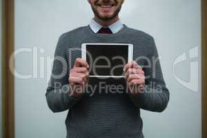Smiling executive holding digital tablet