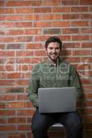 Male executive using laptop in waiting area