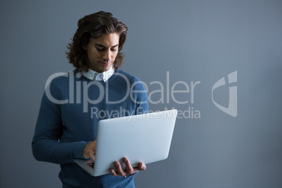 Male executive using laptop in office