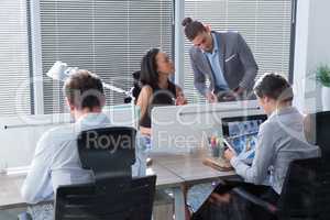 Businessman discussing with her coworker on digital tablet