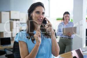 Smiling female executive talking on phone