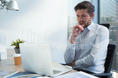 Thoughtful male executive looking at laptop