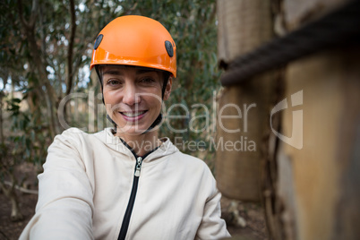 Portrait of woman wearing safety helmet standing in forest