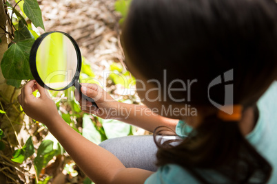Little girl exploring nature through magnifying glass