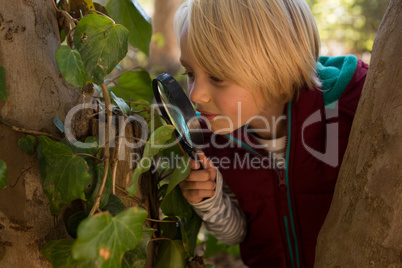 Little girl exploring the nature through a magnifying glass