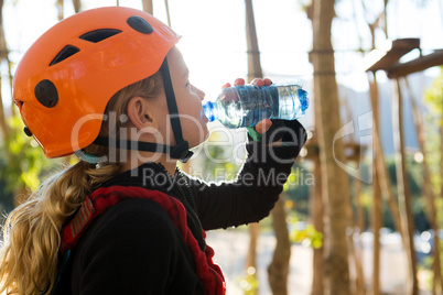 Little girl wearing helmet drinking water