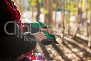 Little girl removing her hand gloves in the forest