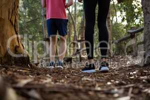 Legs of man and woman standing in forest