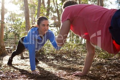 Woman and man doing push ups on a sunny day