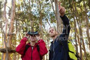 Man pointing out while woman using binoculars