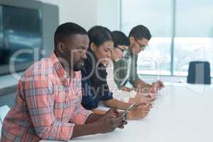 Male and female executives using electronic gadgets