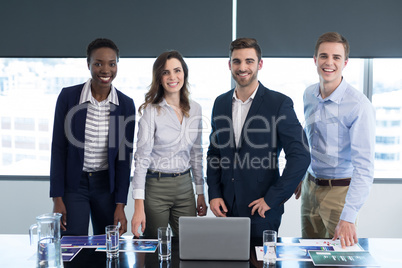 Portrait of confident executives standing at desk