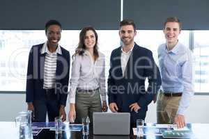 Portrait of confident executives standing at desk