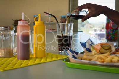 Man pouring drink into glass at restaurant