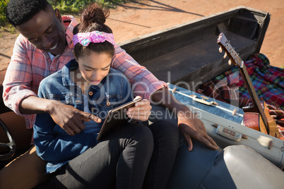 Couple using digital tablet in car