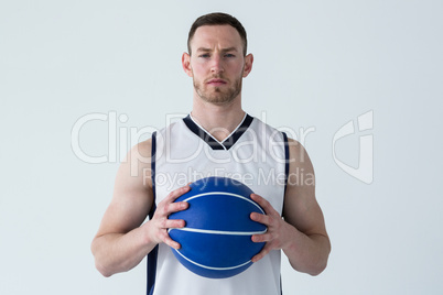 Basketball player holding ball against white background