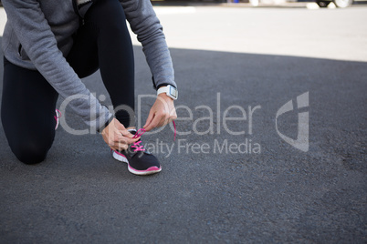 Female jogger tying her shoe laces