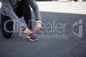 Female jogger tying her shoe laces