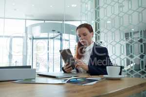 Female executive using digital tablet at desk