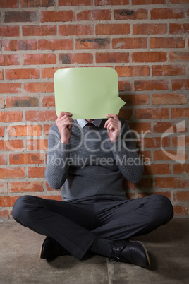 Male executive hiding his face with speech bubble