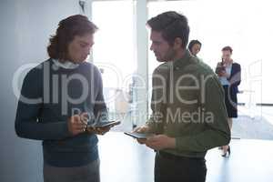 Male executives discussing over digital tablet