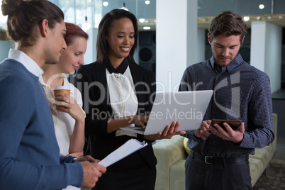 Business colleagues discussing over laptop