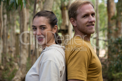 Hiker couple standing back to back in the forest