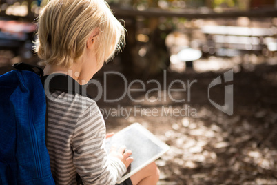 Little girl with a backpack using a tablet