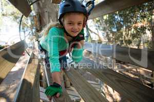 Little girl wearing helmet trying to cross obstacle