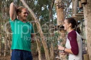 Trainer exercising while woman holding water bottle