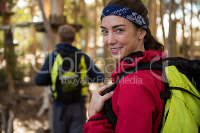 Woman with backpack smiling man walking in background