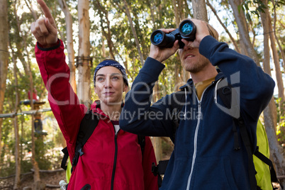 Woman pointing out while man using binoculars