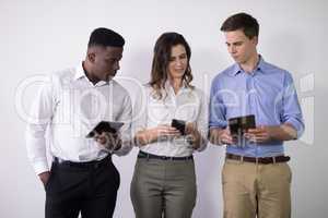 Male and female executives using electric gadgets