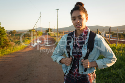 Woman standing with backpack on a road