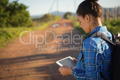 Young woman with backpack holding tablet