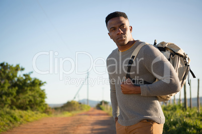 Man standing with backpack at countryside