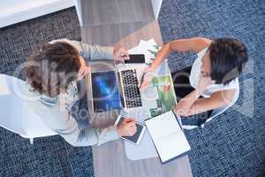 High angle view of business executives discussing over laptop