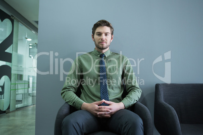 Confident executive sitting on chair in waiting area