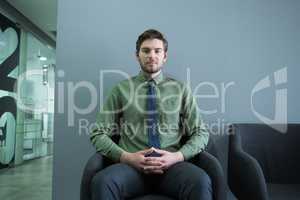 Confident executive sitting on chair in waiting area