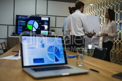 Female executive shaking hands with male executives