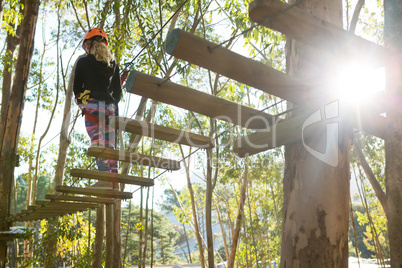 Little girl wearing helmet walking on wooden bridge