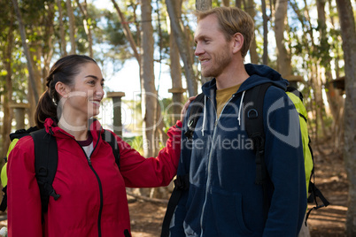 Woman keeping her hand on man shoulder standing in forest