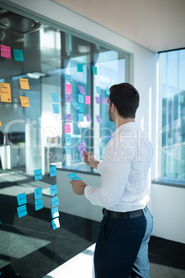 Male executive reading sticky note