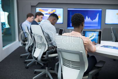 Male and female executives using laptop during meeting