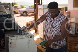 Man filling petrol in car at petrol pump