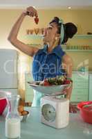 Woman having a strawberry at home