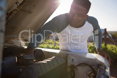 Man repairing car at countryside